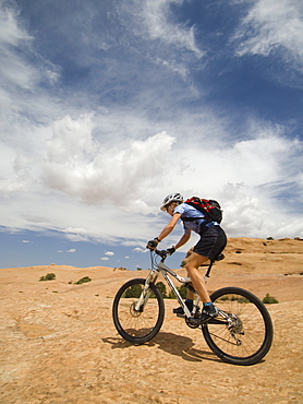 Woman riding mountain bike in desert