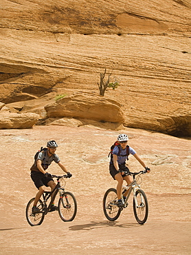 Couple riding mountain bikes in desert