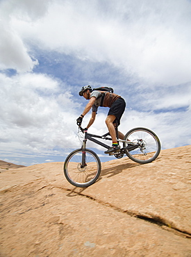 Man riding mountain bike on rock formation