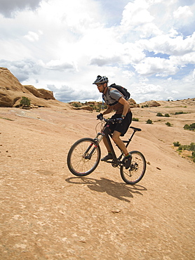 Man riding mountain bike on rock formation
