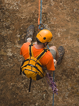 Man rappeling down cliff