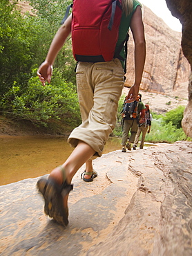 People hiking next to stream