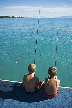 Brothers fishing off dock in lake, Utah, United States