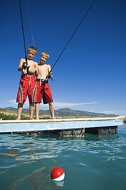 Brothers fishing off dock in lake, Utah, United States