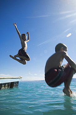 Brothers jumping off dock into lake, Utah, United States