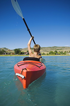 Boy paddling in canoe on lake, Utah, United States