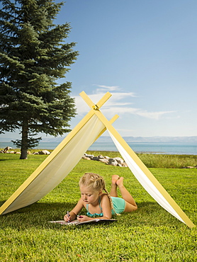 Girl (2-3) lying in tent, Garden City, Utah