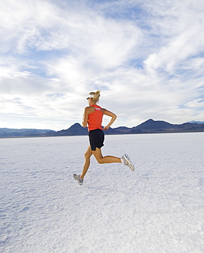 Woman running on salt flats, Utah, United States