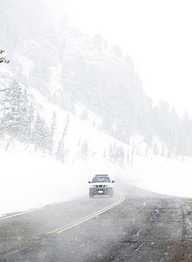 Car driving on snow road, Wasatch Mountains, Utah, United States