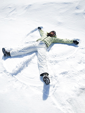 Woman making snow angel