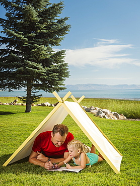 Father and daughter (2-3) playing in tent, Garden City, Utah