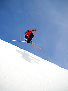 Skier jumping off lip of half-pipe