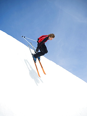 Skier dropping in to half-pipe