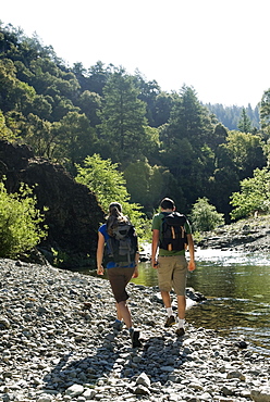 Hikers walking along river