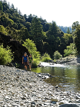 Hikers walking along river