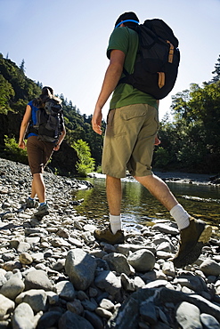 Hikers walking along river