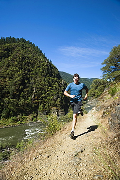 Man running on riverside trail