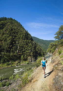 Woman running on riverside trail