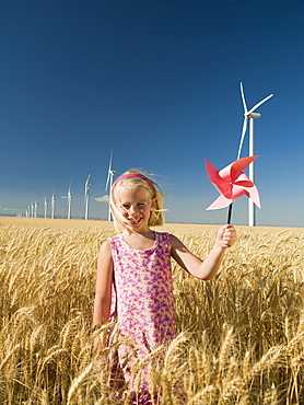 Girl holding pinwheel on wind farm