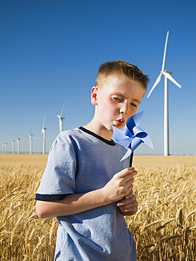 Boy holding pinwheel on wind farm