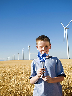 Boy holding pinwheel on wind farm