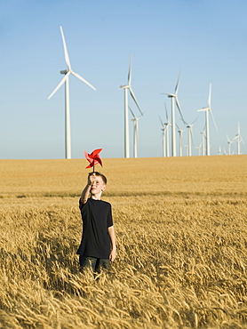 Boy holding pinwheel on wind farm