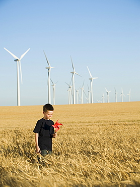 Boy holding pinwheel on wind farm