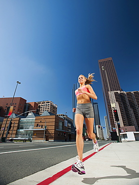 USA, California, Los Angeles, Young woman running on city street, USA, California, Los Angeles