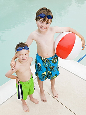 Brothers posing by swimming pool