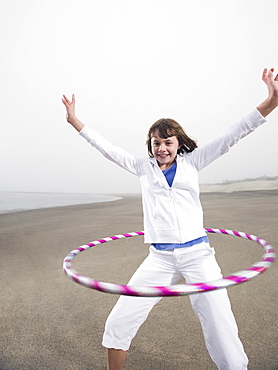 Portrait of girl with hula hoop on beach