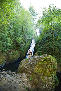 Hikers in front of waterfall