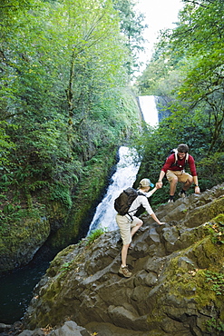 Hikers in front of waterfall