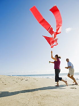 Couple flying kite on beach