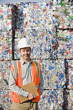 Worker standing in front of crushed aluminum cans