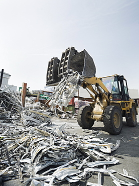 Backhoe lifting recycled metal