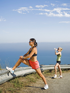 Runner stretching on the side of the road