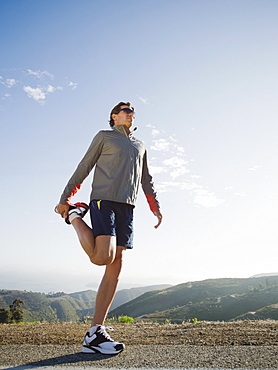 Runner stretching on the side of the road