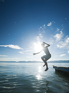 Boy (10-11) jumping from raft
