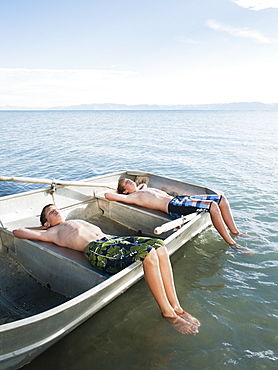 Boys (10-11,12-13) resting on boat