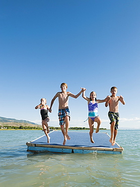 Kids (6-7,8-9,10-11,12-13) playing on raft on lake