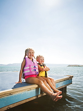 Girls (2-3, 4-5) sitting at the edge of raft in life jackets