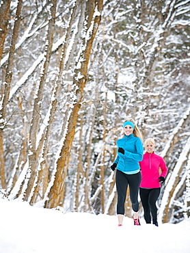 Two women jogging in winter forest, Salt Lake City, Utah USA