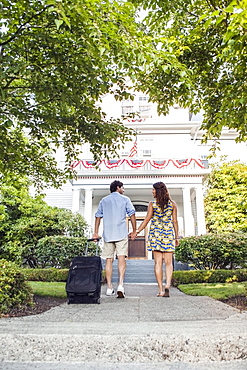 Rear view of couple walking towards hotel, USA, Washington, Everett 