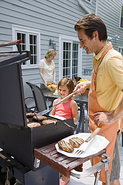 Family barbequing on deck