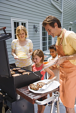 Family barbequing on deck