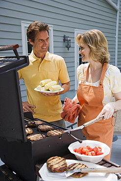 Couple barbequing on deck