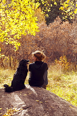 Woman and her collie sitting on stone, Colorado, USA