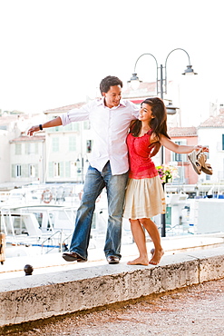 France, Cassis, Couple balancing on stone wall, France, Cassis