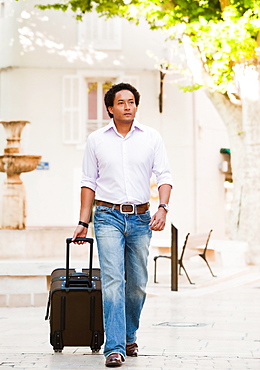 France, Cassis, Man walking with suitcase, France, Cassis