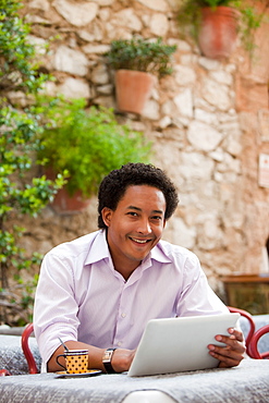 France, Cassis, Man using digital tablet in cafe, France, Cassis